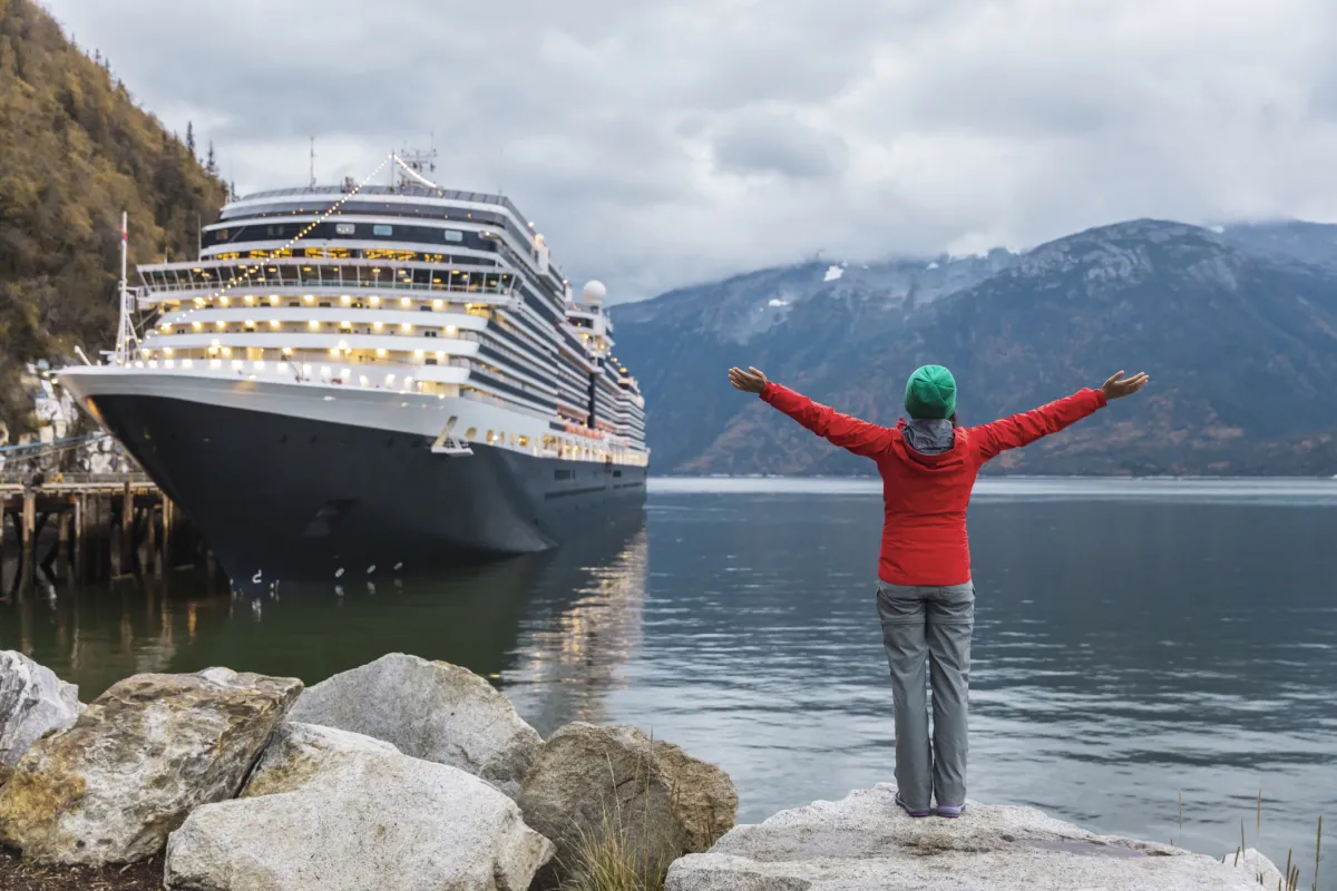 happy woman tourist with open arms going on vacation in Alaska 