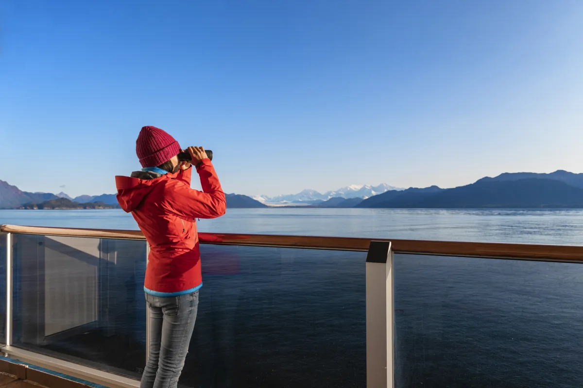 Woman with binoculars on an Alaska cruise